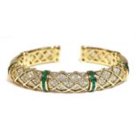 An emerald and diamond sprung torque bangle,