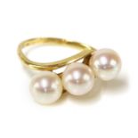 A three stone cultured pearl crossover ring, by Mikimoto,