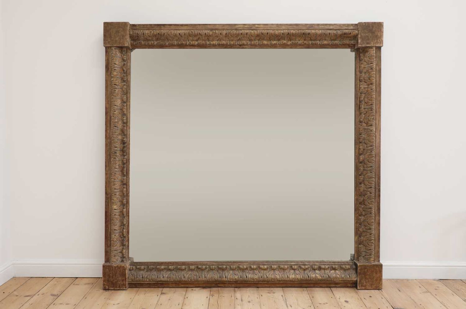 A monumental carved pine-framed wall mirror,