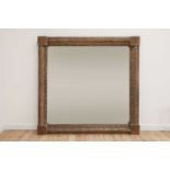 A monumental carved pine-framed wall mirror,