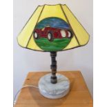 An unusual table lamp made from a racing car part; the Tiffany-style predominately yellow glass