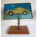 An unusual table lamp made from a racing car part and with the Tiffany-style glass shade modelled