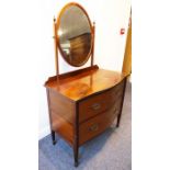 An early 20th century serpentine-fronted mahogany dressing table; the mirrored top above two half-