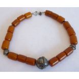 A large 19th century amber necklace set with 18 large barrel-shaped amber beads of burnt-umber