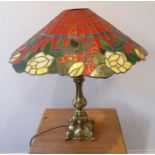 A large and heavy gilt-metal table lamp having Tiffany-style glass shade with yellow roses