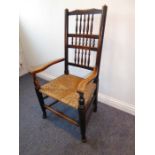 An early 19th century Lancashire-style spindle back open ash armchair having rush seat and turned