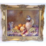 L SUTTON; a gilt-framed oil on artist's board still-life study of a jug, grapes, a glass and oranges