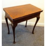 An early 20th century walnut and cross-banded foldover-top card table; the reeded edge top opening