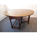 An 18th century oval drop-leaf oak gate leg table raised on turned gun barrelled-style supports;