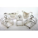 Three hallmarked silver, four-division toast racks; together with a Georgian-style silver sauce boat