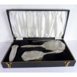 A hallmarked silver dressing table set in its case: four-piece set comprising hand-held mirror, hair