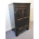 An antique oak side cabinet (part 17th century); single panelled door profusely carved with lozenges