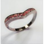 A V-shaped silver ring set with small pink stones  (The cost of UK postage via Royal Mail Special