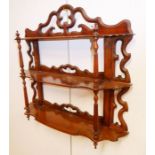 A 19th century set of walnut wall-hanging shelves; pierced gallery above further shelves and