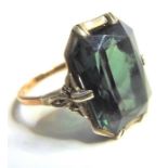 An Art Deco style gold ring set with a large green stone, possibly a green garnet (not tested)