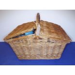 A picnic set within a wicker basket together with two tin strongboxes and a stitched brown-leather