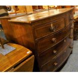 An early 19th century bow-fronted and cross-banded mahogany chest; two half-width over three full-