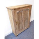 An antique pine wall hanging cupboard having single panelled door (65cm wide)