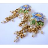 A pair of enamel and seed pearl ear pendants; each enamel flower suspending three fringes, some with