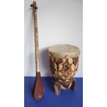 An African drum with stretched skin top together with an unusual two-stringed instrument (also