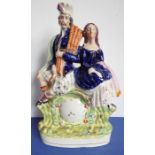 A circa 1870 pottery figure; a Scotsman and his lady seated above a clock, in good condition and