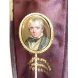 A 19th century yellow-metal stick pin; porcelain portrait miniature, possibly of Sir Walter Scott (