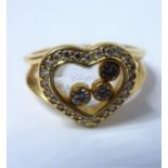 A 'Happy Diamonds' heart-shaped ring by Chopard, the central glazed compartment containing three