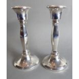 A pair of hallmarked silver table candlesticks; some small 'dings' and lightly engraved postcode
