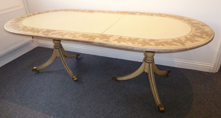 A shabby-chic-style extending oval dining table; the reeded-edge top decorated in paint with