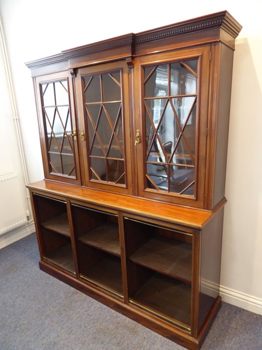 An early 20th century walnut display cabinet/bookcase; the breakfront dentil cornice above three