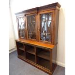 An early 20th century walnut display cabinet/bookcase; the breakfront dentil cornice above three