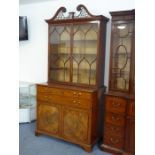 An 18th century mahogany secretaire bookcase; the broken swan-neck pediment pierced in open fretwork