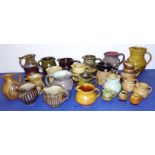 A collection of 24 decorative, mostly studio slipware, jugs; some stoneware, the largest jug (17cm