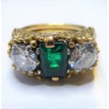 A mid-20th century emerald and diamond three-stone ring: the central rectangular-cut emerald set