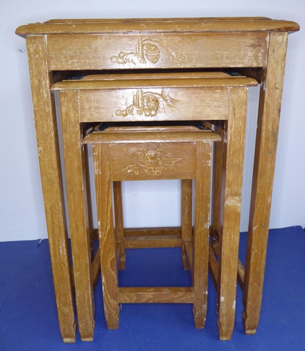 A nest of three Chinese hardwood tables; each top carved with Chinese figures and buildings and