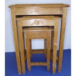 A nest of three Chinese hardwood tables; each top carved with Chinese figures and buildings and