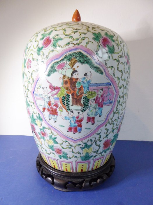 A Chinese porcelain vase of baluster form; the cover decorated with a moth and fruits and above a