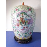 A Chinese porcelain vase of baluster form; the cover decorated with a moth and fruits and above a