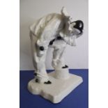 A mid-20th century Continental  figurine of a Pierrot in a sorrowful pose, decorated in black and