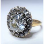 An oval diamond cluster ring; the central oval old brilliant-cut diamond estimated to weigh