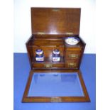 A late 19th century oak stationery cabinet; the moulded hinged lid folding back to reveal fitted