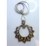 An openwork circular diamond-set pendant set with 13 graduated lasqué-cut diamond collets to the