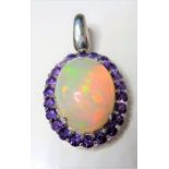 An oval opal and amethyst-set pendant, the central cabochon opal measuring 23mm x 18mm, the