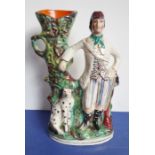 A circa 1870 Staffordshire spill vase; decorated with a figure of a hunter and his seated dog,