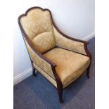 An early 20th century upholstered and mahogany show-frame armchair raised on square tapering legs