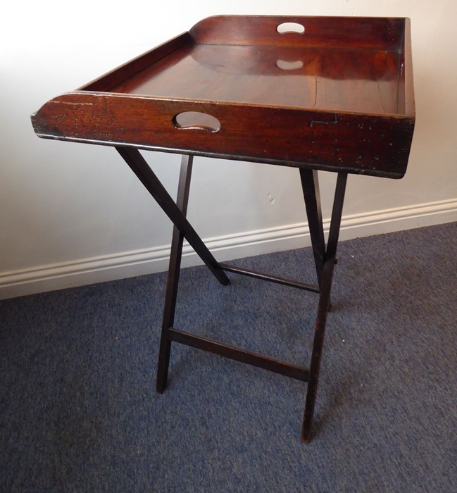A 19th century three-handled mahogany butler's tray on stand; the folding x-frame stand with two