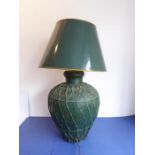 A large baluster-shaped green-painted tin lamp with woven lattice-work effect decoration in relief