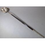 An 18th century white-metal toddy ladle, the base set with a Queen Anne shilling dated 1711 (The