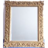 A mid-20th century gilt-framed wall-hanging looking glass having hand-bevelled plate (frame size