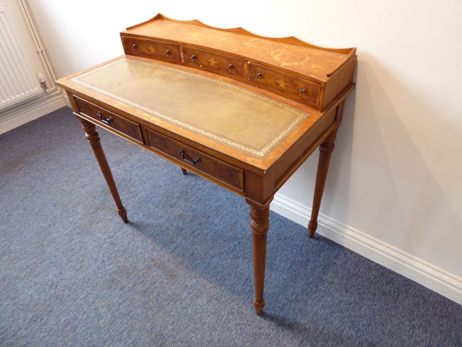 A reproduction yew-wood writing desk; the galleried superstructure with three concave drawers headed